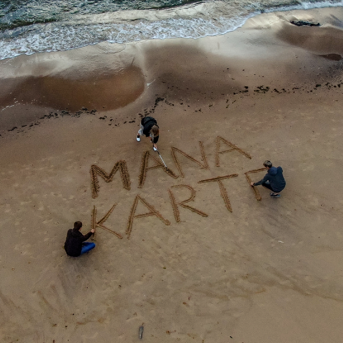 Attēls ar Manas Kartes uzrakstu smiltīs